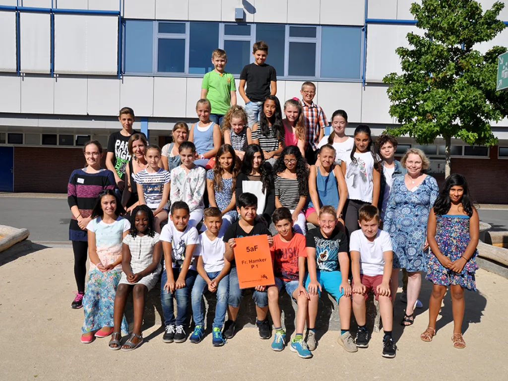 Klassenfoto einer neuen fünften Klasse im Schulhof.